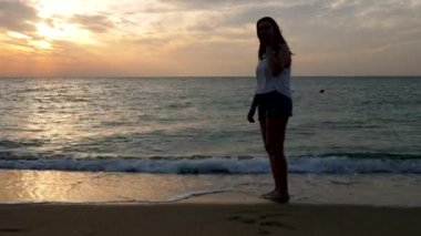 Bir çocuk gibi suda gündoğumu atlama, sahilde mutlu kadınla
