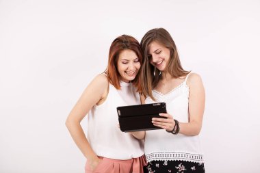 İki kız gülümseyerek ve bir tablet Pc vasıl arıyorum arkadaşlar