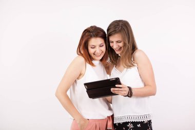İki kız gülümseyerek ve bir tablet Pc vasıl arıyorum arkadaşlar