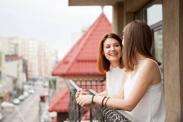 Zwei Freundinnen reden und lachen auf dem Balkon — Stockfoto