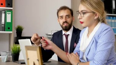Bilgisayar ekranı önünde konuşurken iş ortakları
