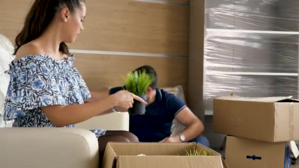 Man and woman unpacking from cardboad boxes — Stock Video