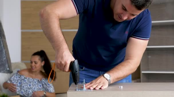 Zoom in man assembling furniture in new house — Stock Video