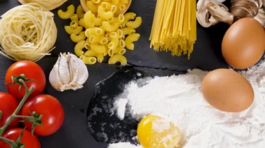 Karanlık masada pişmemiş makarna, makarna ve spagetti