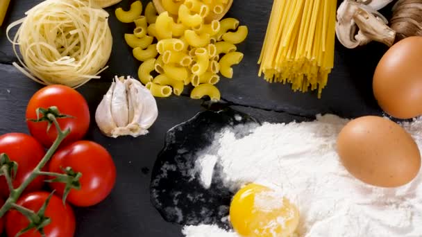 Неприготовленная сырая макароны рядом с другими ингредиентами на ужин — стоковое видео