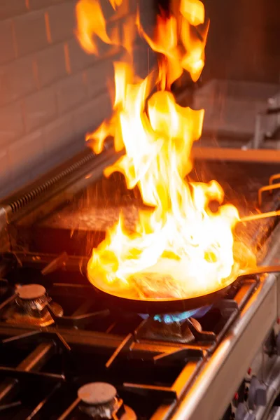 Chef cooking with high fire in kitchen — Stock Photo, Image