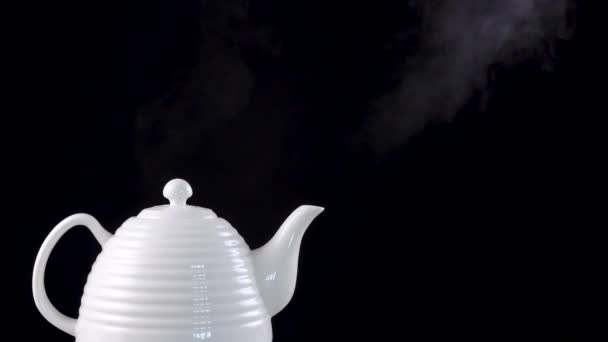 Tea pot on black background with boiling water — Stock Video