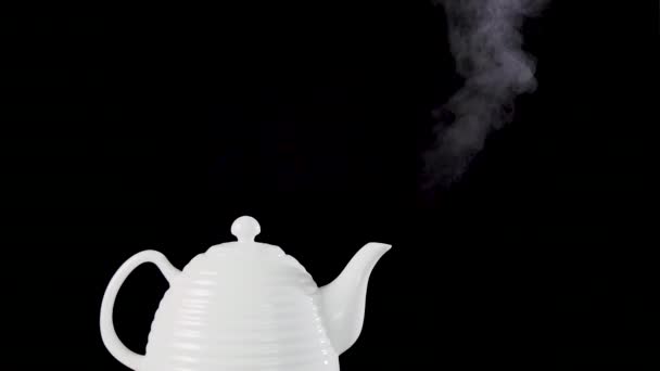 Tea pot on black background with boiling water — Stock Video