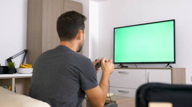 Onun koltukta otururken joystick ile oynayan adam.