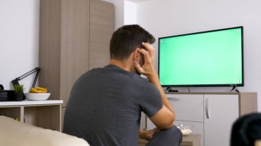 Onun koltukta otururken joystick ile oynayan adam.