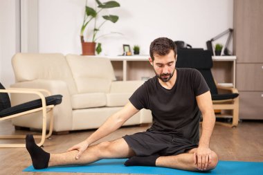 Genç adam onun oturma odasında pratik yoga