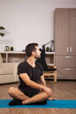 Tiwst yoga pozlar olurken ev yapan erkek
