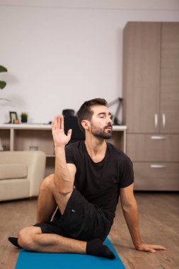 Çekici bir genç adam yarı Tanrı balıklar yoga yapıyor poz