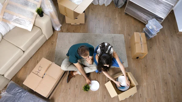 Genç çift yeni ev taşıma ve carboard kutuları açma.