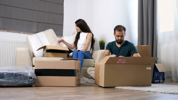 Молодая пара переезжает в новый дом и распаковывает картонные коробки . — стоковое фото