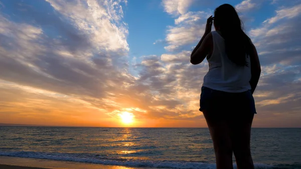 Donna che si rilassa al mare ammirando il tramonto — Foto Stock