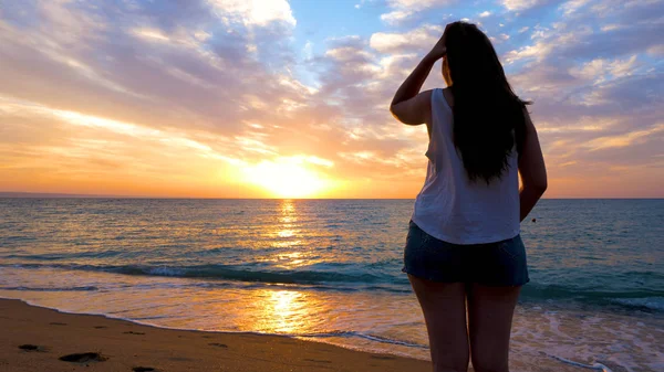 Donna che si rilassa al mare ammirando il tramonto — Foto Stock