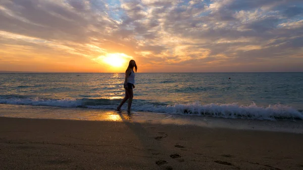 Donna che si rilassa al mare ammirando il tramonto — Foto Stock