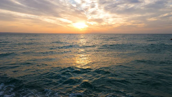 Sonne in den Wolken bei Sonnenuntergang über dem Meer. — Stockfoto