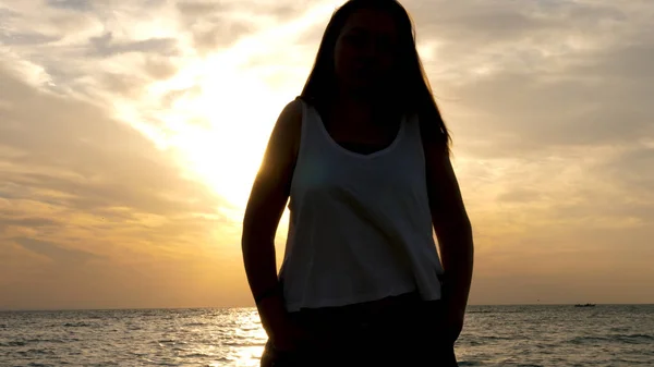 Draguta femeie tânără pe plajă admirând apusul soarelui . — Fotografie, imagine de stoc