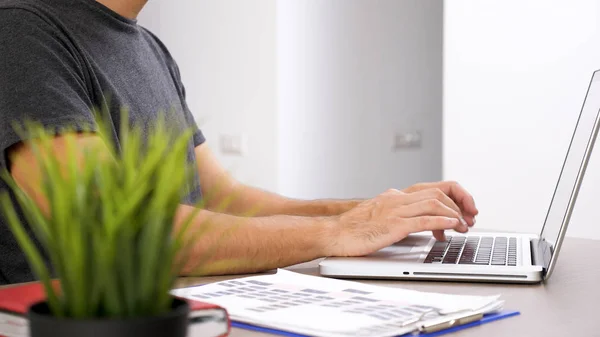 Fiatal ember dolgozik a laptop az üzleti dokumentáció. — Stock Fotó