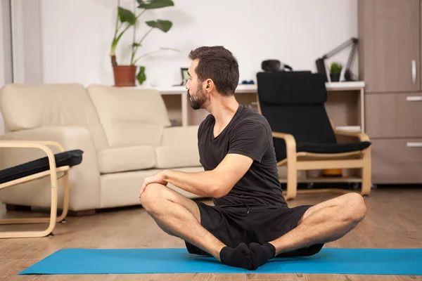 Man tiwst yoga houdingen terwijl thuis doen — Stockfoto