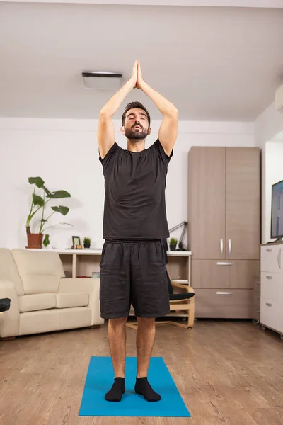 Fit mens beoefenen van yoga in de woonkamer — Stockfoto