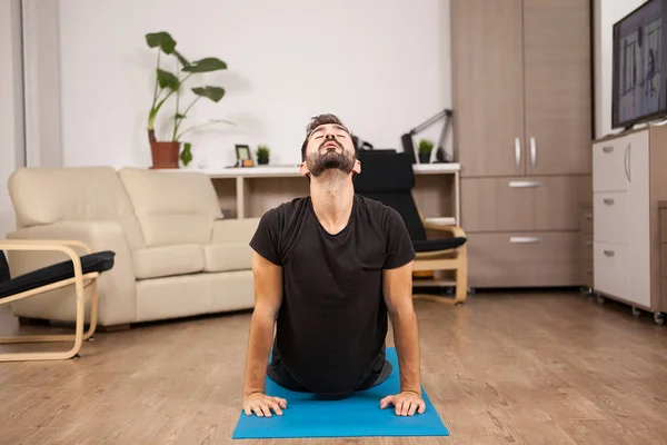 Jong volwassen cobra yoga doen poseren op de vloer van zijn huis — Stockfoto