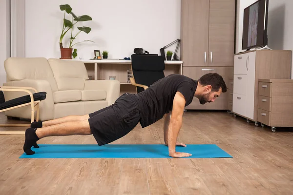 Bearded man doing push ups on the floor of his house. — Stock Photo, Image
