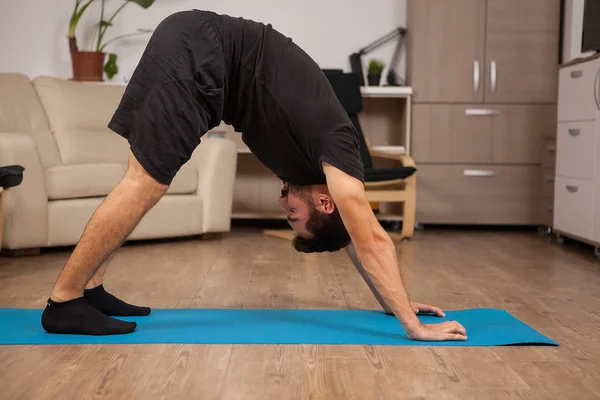Volwassen man doen Dolphin yoga houding in zijn trainingroutine — Stockfoto