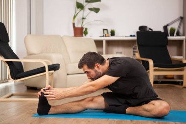 Genç adam onun oturma odasında pratik yoga