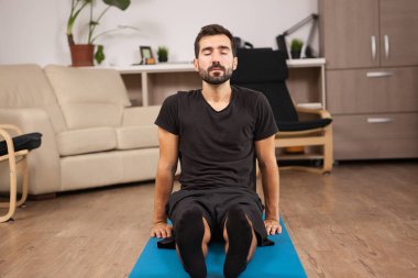 Paschimottanasana yoga poz yapıyor katta oturan genç adam