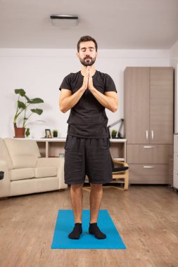 Adam pratik yoga oturma odasında uygun