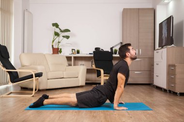 Genç Yetişkin kobra yoga yaparken onun evi katta poz