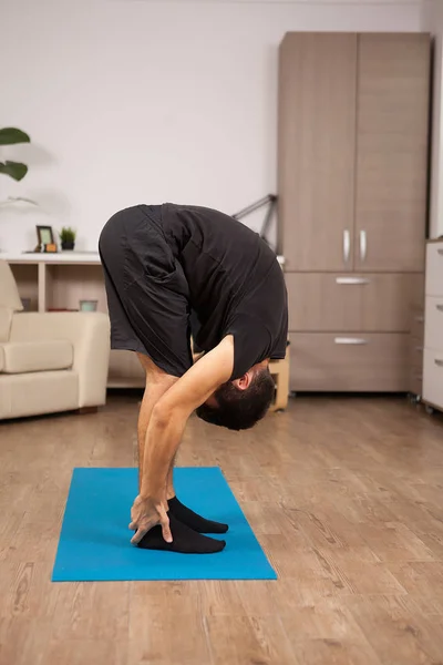 Adult man doing big toe yoga pose while working out — Stock Photo, Image