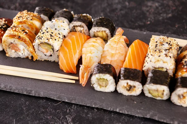 Siyah arka plan üzerine çeşitli karışımı suşi rulo