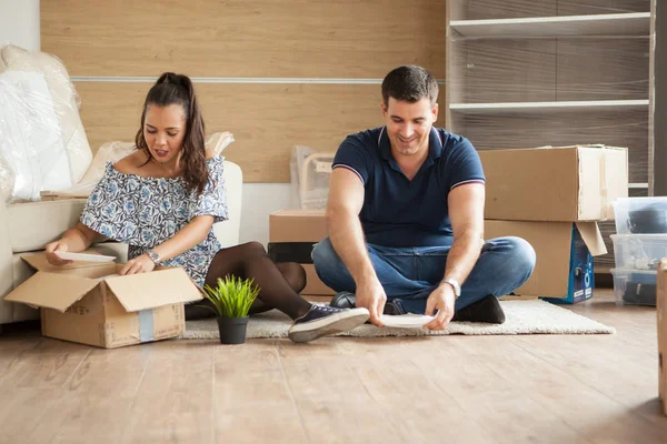 Счастливая молодая пара распаковывает коробки в новой квартире — стоковое фото