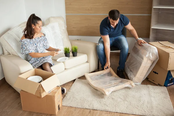 Genç çift yeni ev taşıma ve carboard kutuları açma. Hareketli bitmiş.