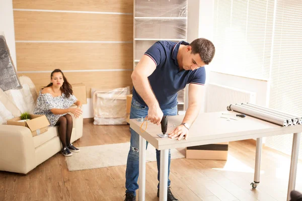 Человек использует инструменты для сборки мебели в новом доме . — стоковое фото