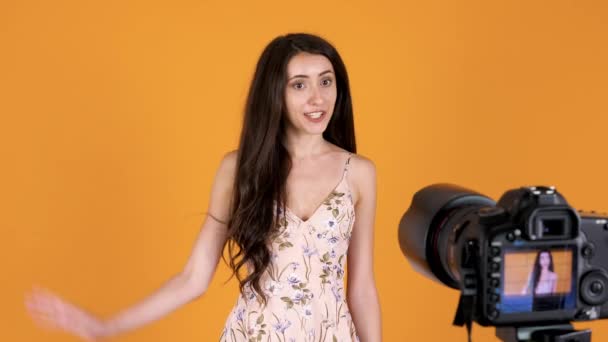 Mulher lindo no vestido de verão vlogging na frente da câmera DSLR — Vídeo de Stock