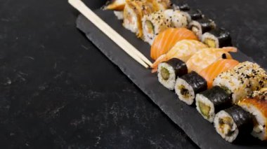 Geleneksel suşi rulo siyah taş plaka üzerinde