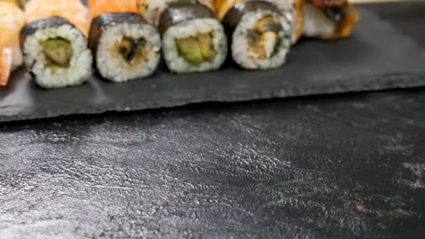Tradycyjne japońskie sushi rolki na czarnej płycie — Wideo stockowe