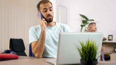 Adam görüşmeler önünde ona karın video oyunları bir konsol üzerinde oynarken bir dizüstü bilgisayar ile telefon