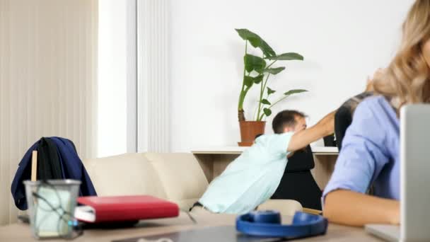 L'uomo fa un sacco di rumore guardando una partita di sport in TV mentre la sua ragazza cerca di lavorare sul computer — Video Stock