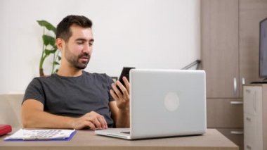 Adam video konferans yoluyla onun telefonda konuşurken oturma odasında onun masasında