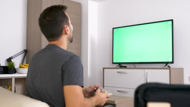Adulto homem na frente de grande verde mock-up tela de TV jogando um jogo de vídeo no console — Vídeo de Stock