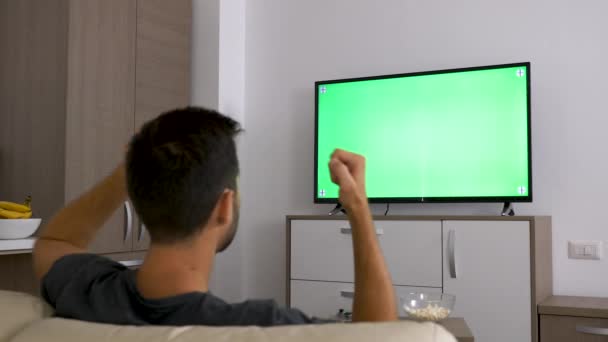 Ember egy nagy zöld modell képernyő Tv nézés — Stock videók