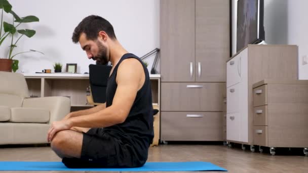 Vista Lateral Del Joven Forma Estirándose Sobre Una Alfombra Azul — Vídeo de stock