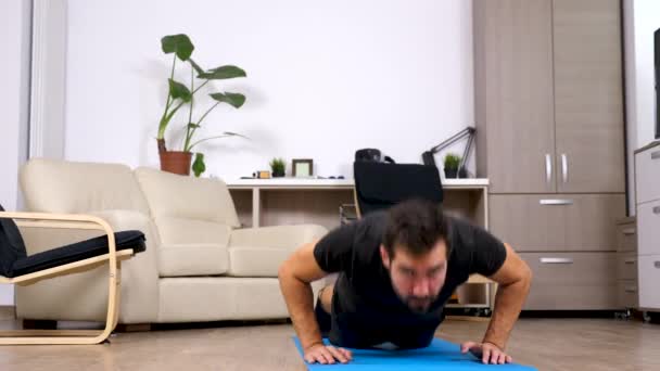 Hombre atlético haciendo flexiones en casa — Vídeos de Stock
