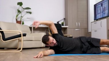 Genç adam evde egzersizi yaparken uygun